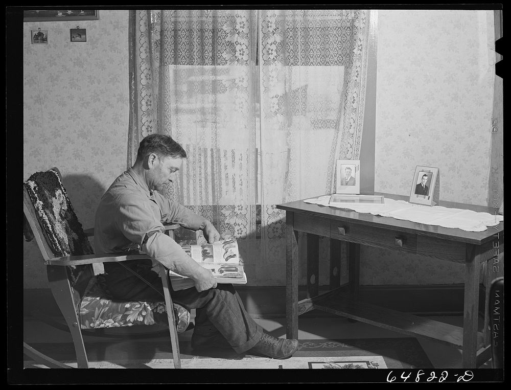 Adams County, North Dakota. George P. Moeller looking through a mail order catalog. Sourced from the Library of Congress.