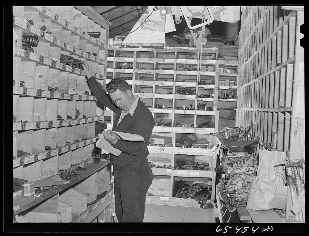 Wisdom, Montana. Len Smith in the stockroom of the Basin Mercantile Company. They have an extremely large stock of tractor…