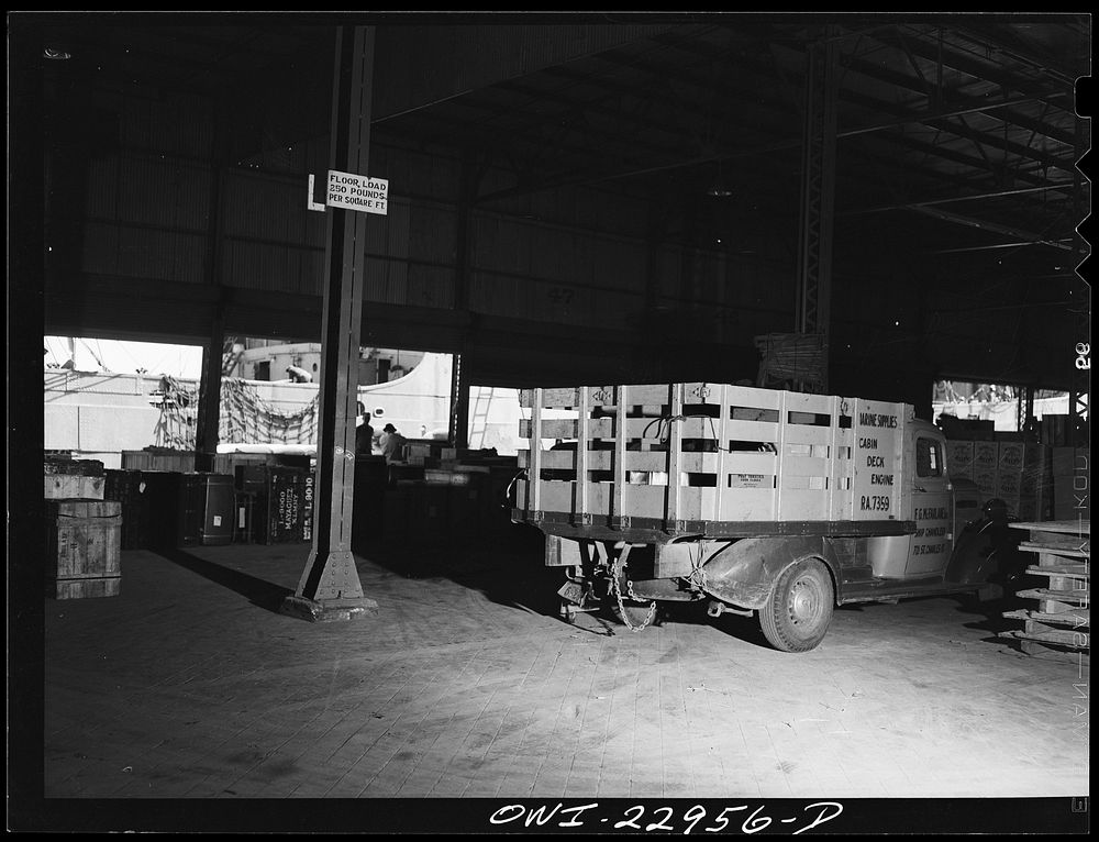 New Orleans, Louisiana. Trucks unloading goods in a warehouse at the Poydras Street dock. Sourced from the Library of…