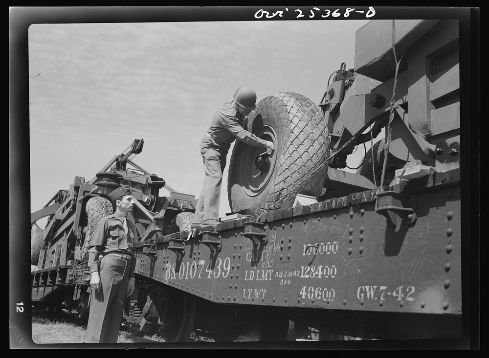 Holabird ordnance depot, Baltimore, Maryland. An officer checking the air pressure of giant tires on LeTourneau roadscrapers…