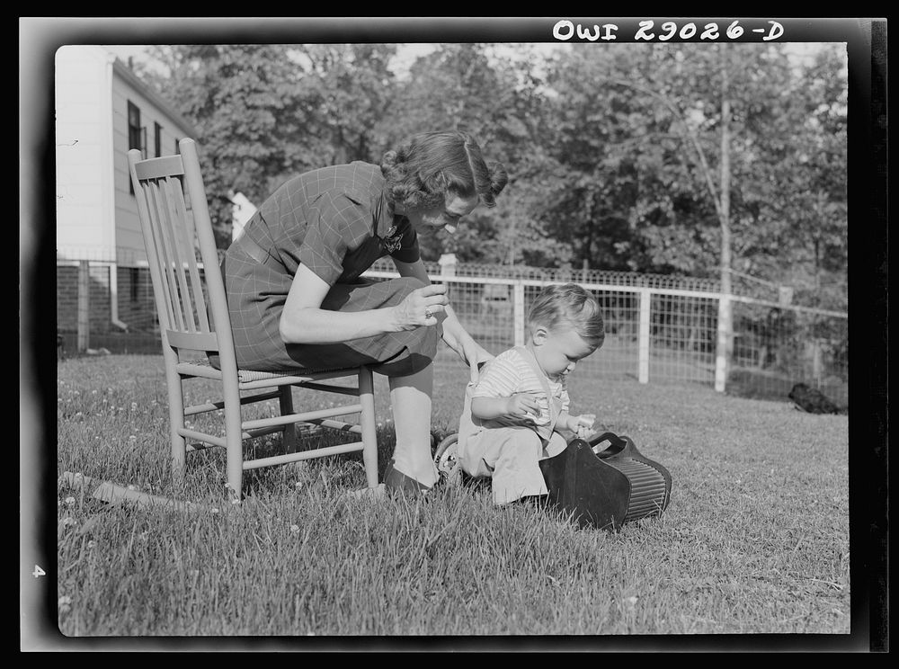 [Untitled photo, possibly related to: A mother sewing a button on her child's overalls. Silver Spring, Maryland]. Sourced…