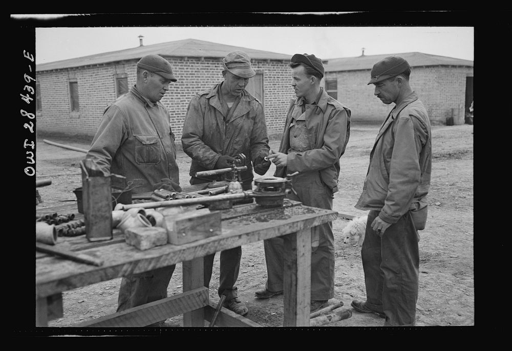 American troops working on their billets somewhere in Iran. Left to right: Private Irvin George Wood of Oil Field, Kansas;…