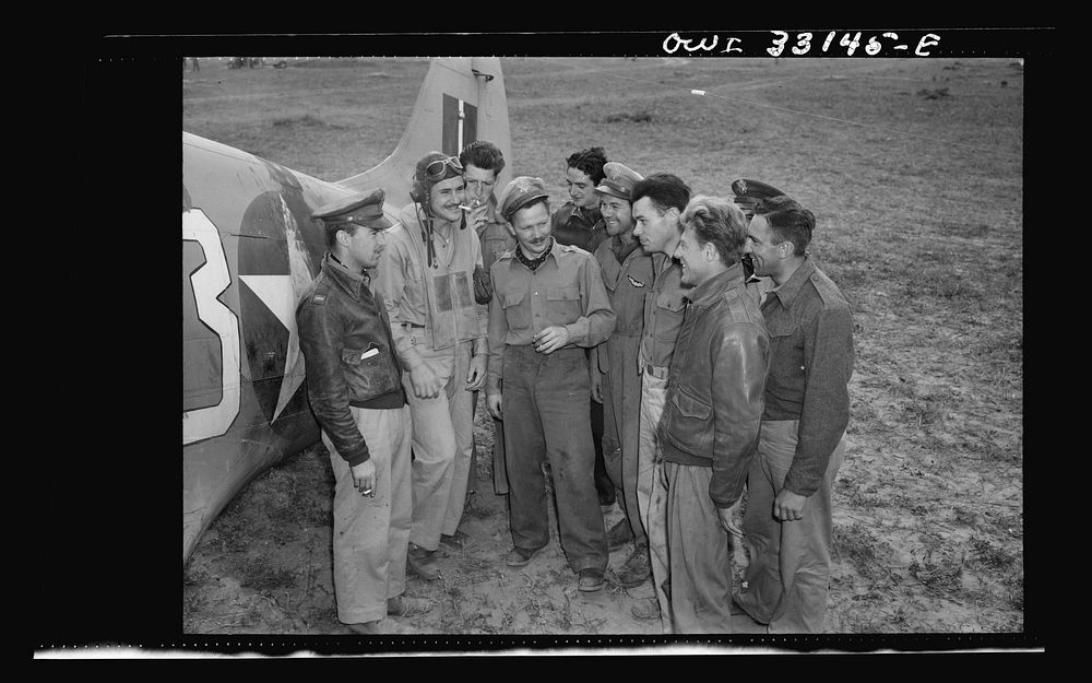 Major Glade B. Bilby of Skidmore, Montana talking to members of his flying squadron somewhere in Tunisia. While flying top…