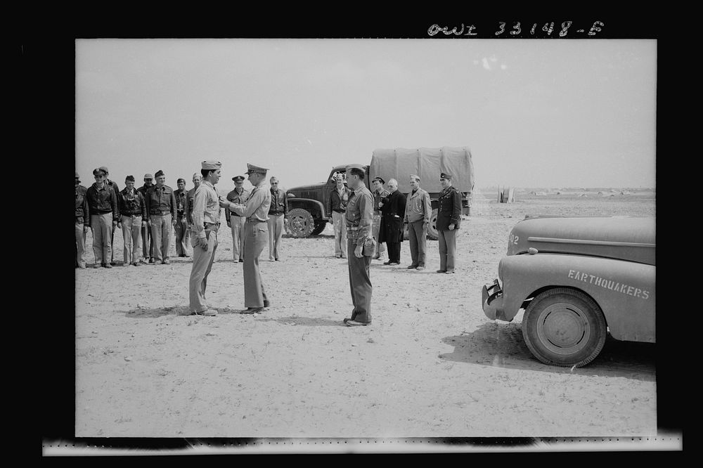 An American sergeant receiving a decoration during the North African campaign. Archbishop Spellman of New York is watching…