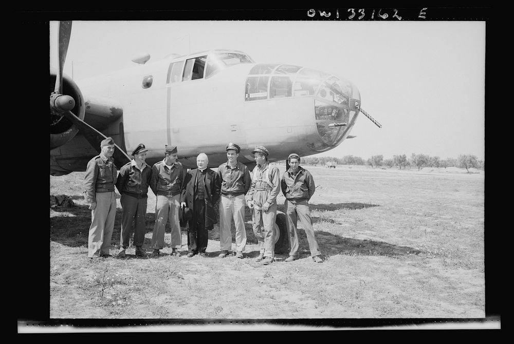 Archbishop Spellman of New York posing with the crew of a B-25 medium bomber at the farthest advanced U.S. bomber base in…