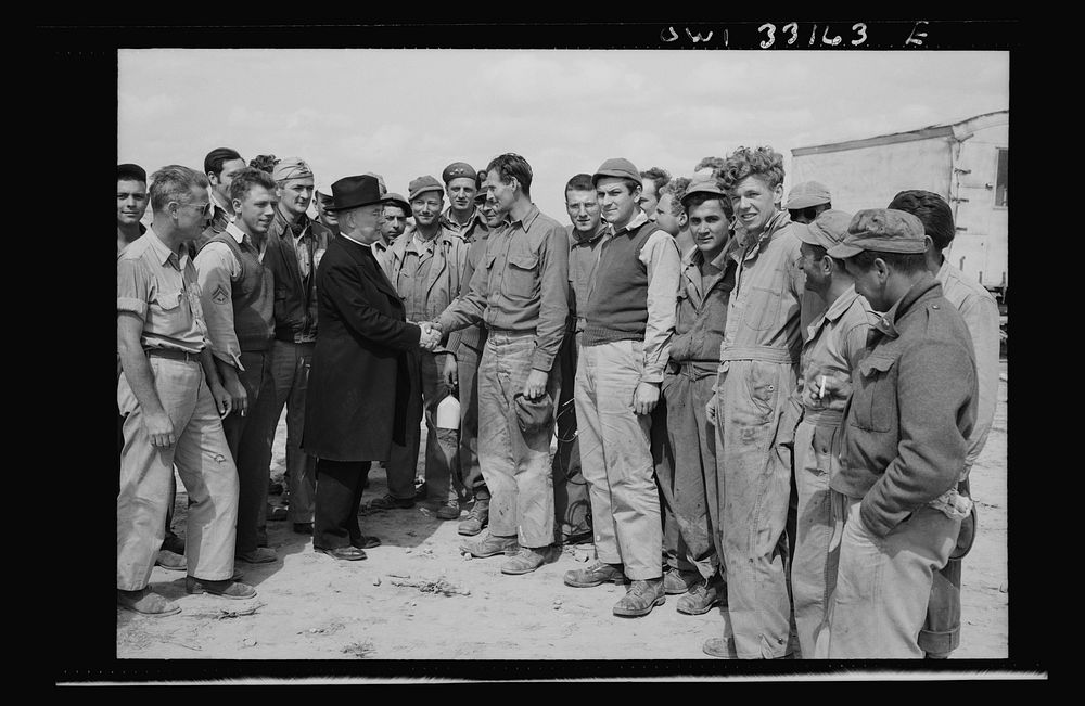 Monsignor Spellman shaking hands with Corporal George T. Robinson while touring the Tunisia front. When Archbishop Francis…