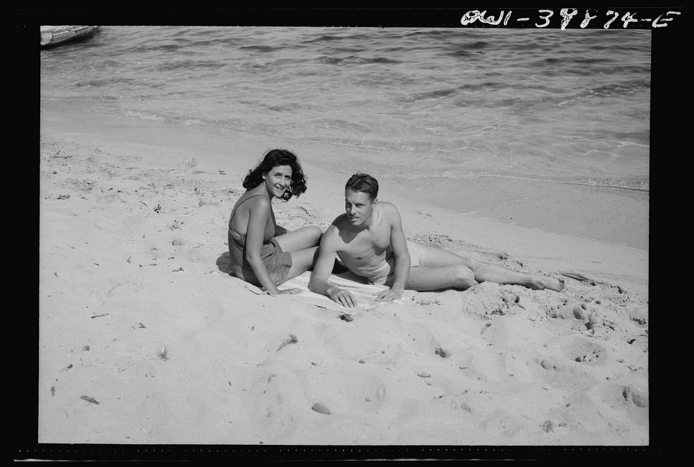 A young couple on the beach in Sicily. The people are gradually returning to normal recreations. Sourced from the Library of…