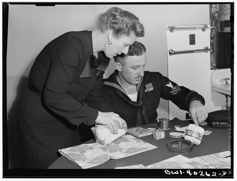 Washington, D.C. A sailor getting some help in wrapping his Christmas gifts at the United Nations service center. Sourced…