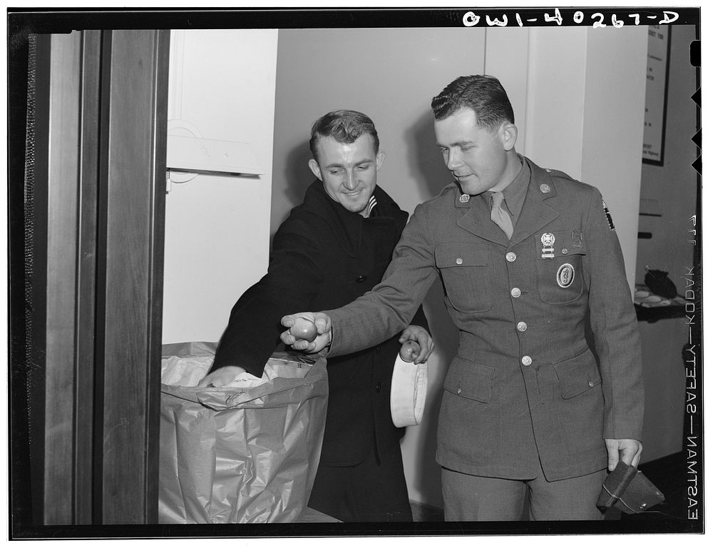 Washington, D.C. Sampling a basket of apples which was given to servicemen at the United Nations service center by the…