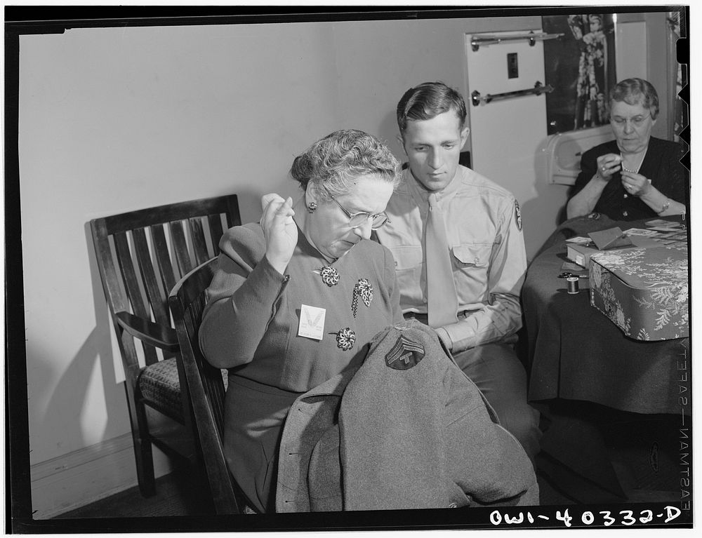Washington, D.C. A volunteer at the United Nations service center sewing insignia and newly-acquired chevrons on the…