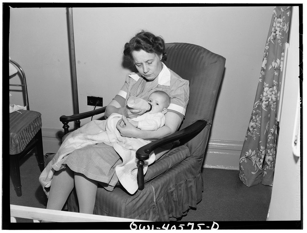 Washington, D.C. A volunteer worker feeding a baby at the nursery of the United Nations service center. Sourced from the…