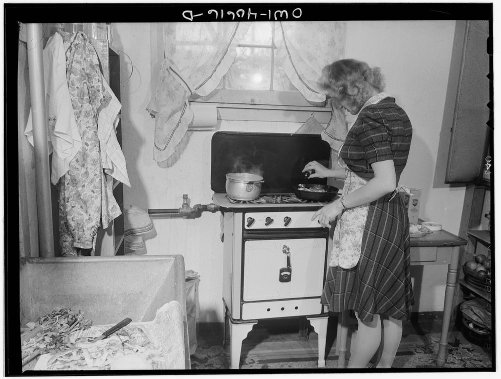Washington, D.C. Lynn Massman, wife of a second class petty officer who is studying in Washington, cooking dinner. Sourced…