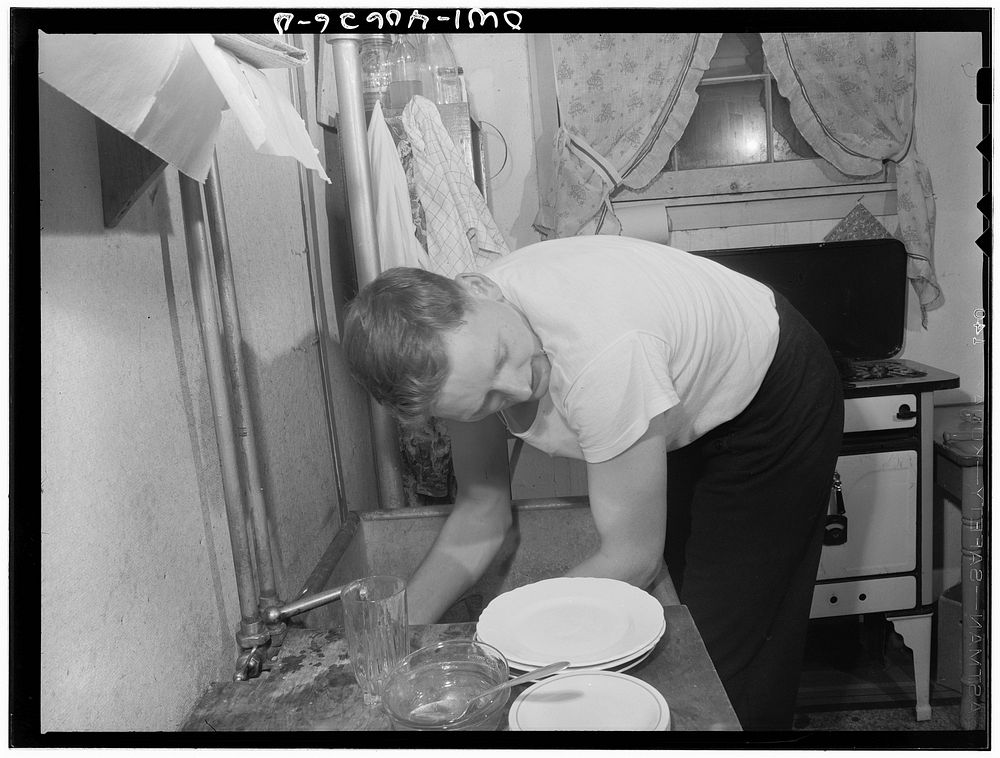 Washington, D.C. After dinner, Hugh Massman, a second class petty officer who is studying in Washington, does the dishes…