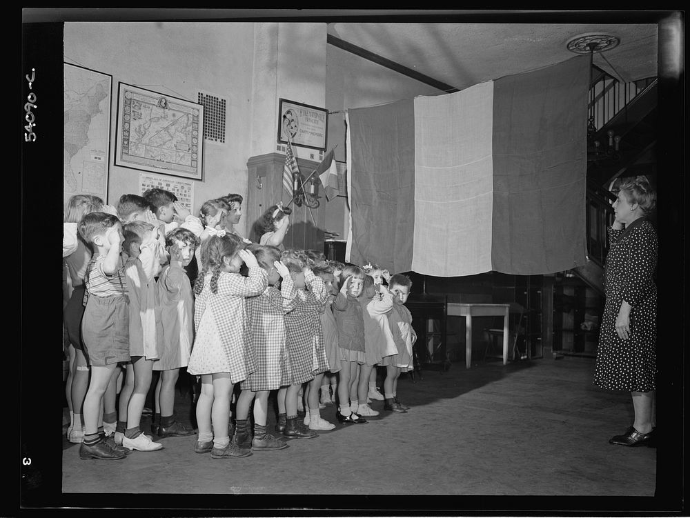 New York, New York. June 6, 1944. Preschool age children at L'Ecole maternelle francaise on D-day saluting the French flag.…