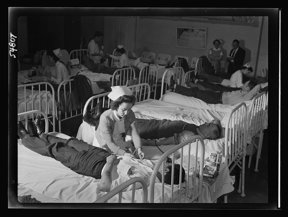 Mrs. Evelyn Hauser, Red Cross nurse, prepares a volunteer blood donor at San Quentin for his donation. During the Red Cross…