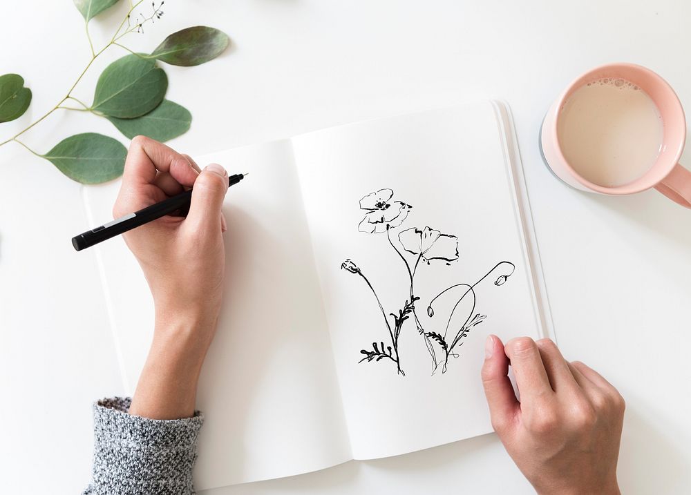 Woman drawing flowers on a diary