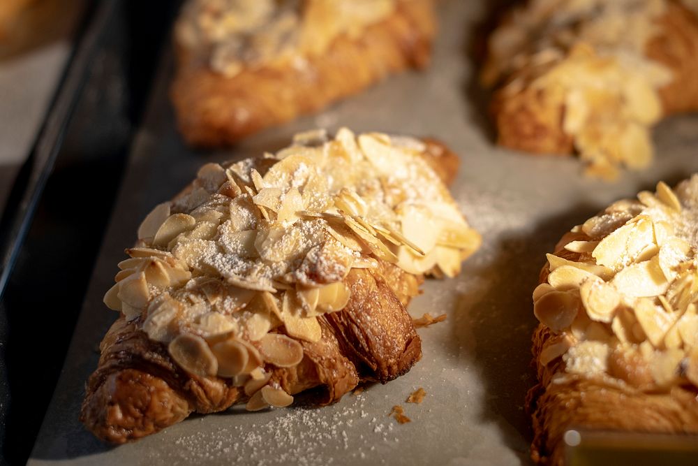Fresh baked almond croissants on display at a cafe