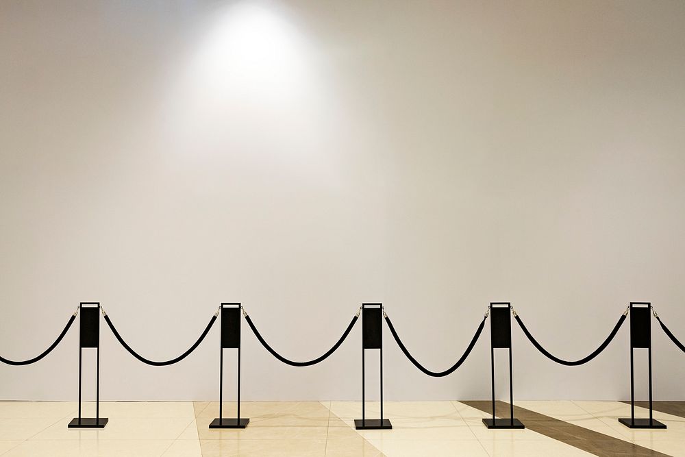 Beige wall with rope barricade in the gallery
