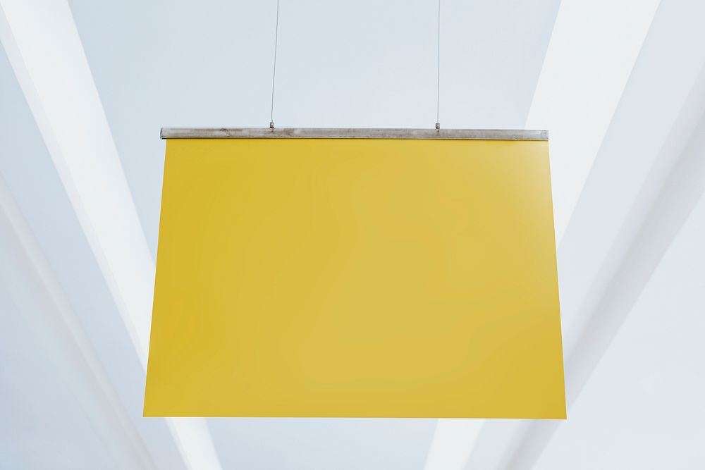 Yellow poster sign hanging from a ceiling