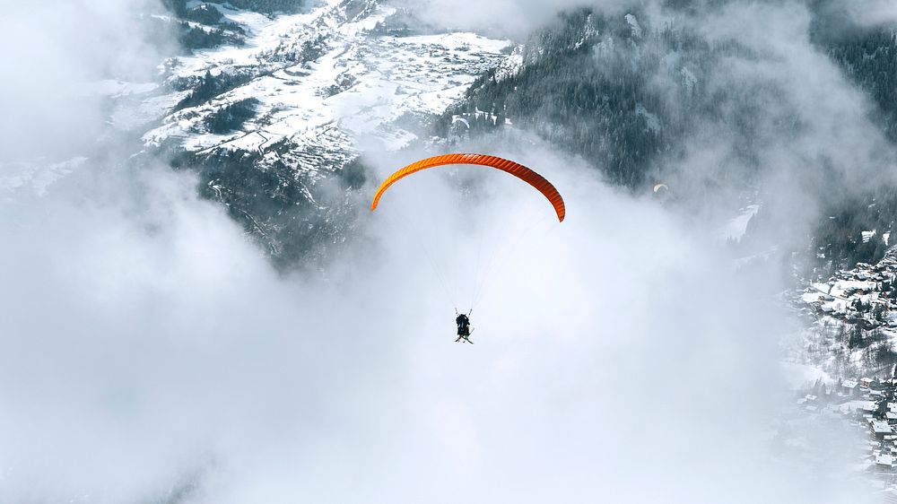 Nature desktop wallpaper background, paragliding on a cloudy day through the mountain