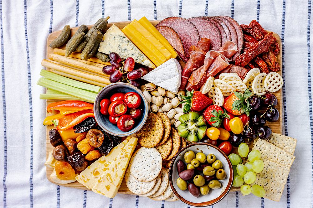 Charcuterie board with cold cuts, fresh fruits and cheese close up