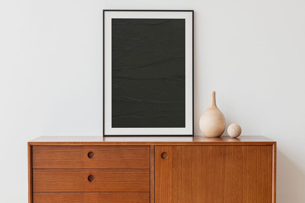 Black picture frame on wooden cabinet