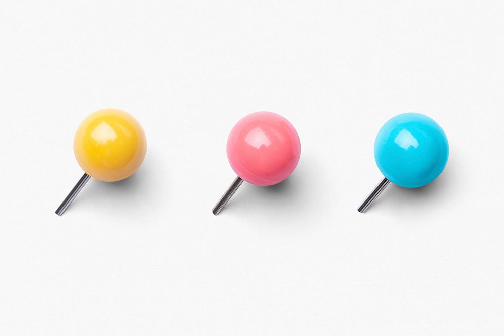 Colorful push pins, white background