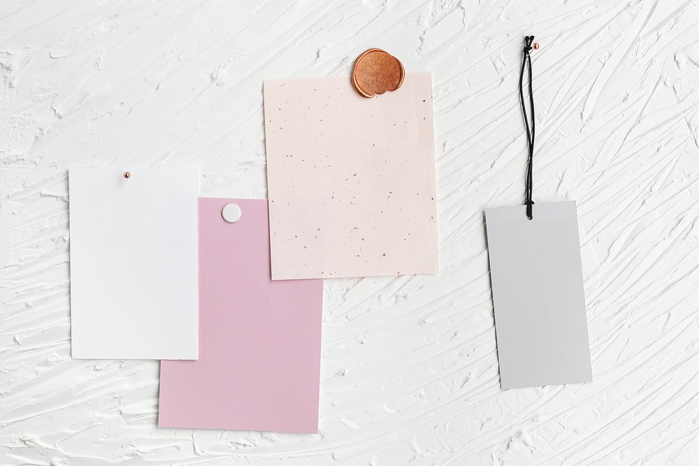 Blank note papers, label tag pinned on textured white background
