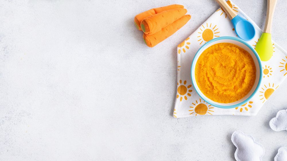 Healthy baby food background, organic carrot puree