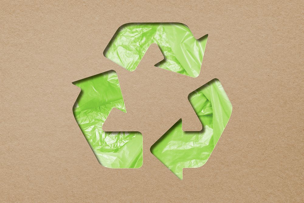 Green recycling symbol plastic bags on brown paper craft background