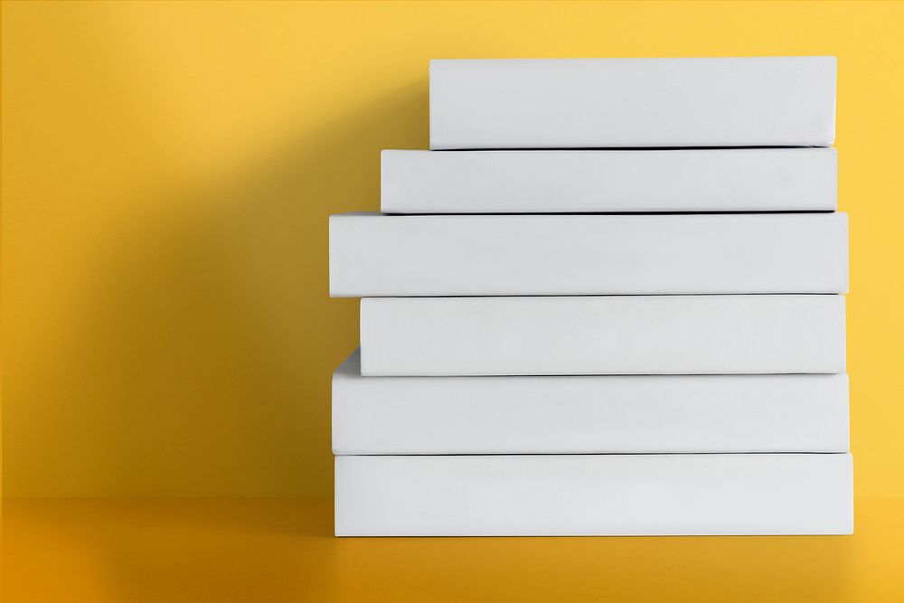 White hardcover books stacked in a pile with design space