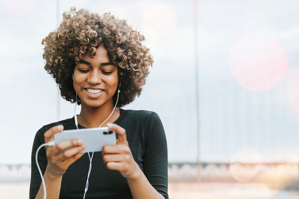 African American woman holding smartphone remixed media 