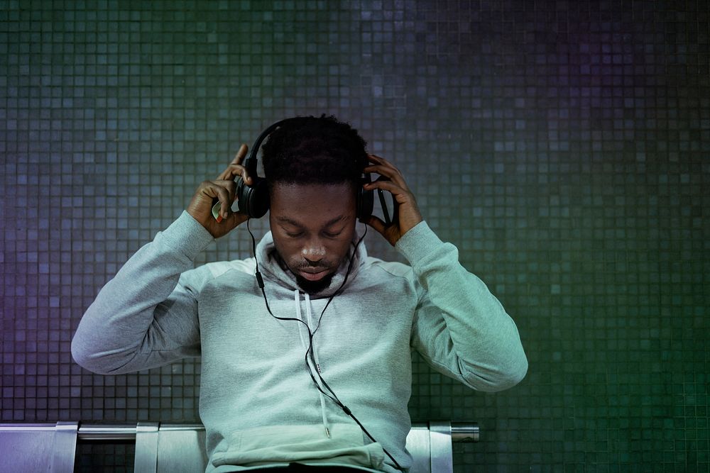 African American man putting on headphones at the subway