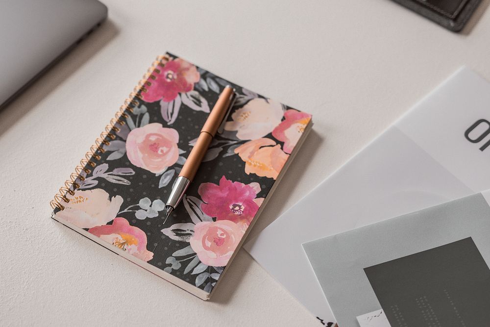 Aesthetic floral notebook and pen on a table