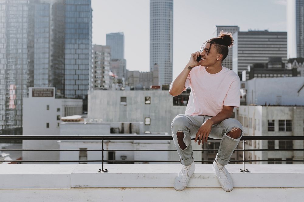 Cool man chatting on a phone at rooftop balcony