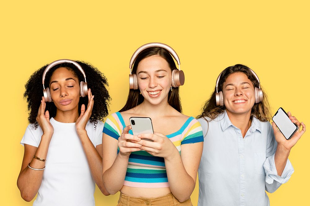 Women streaming music, isolated on yellow