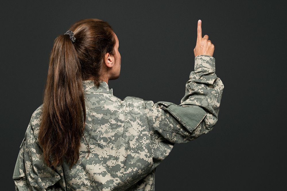 Female soldier pressing index finger on an invisible screen
