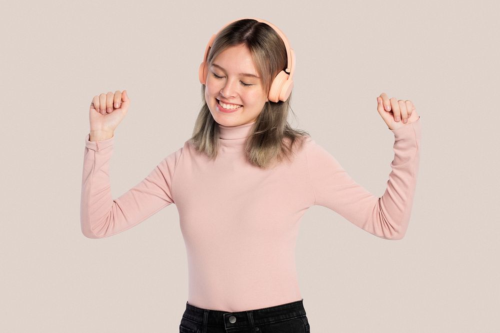 Happy woman listening to music from headphones