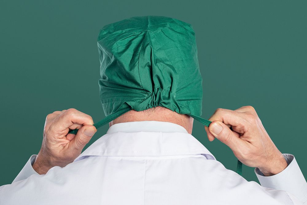 Male surgeon wearing a green surgical cap