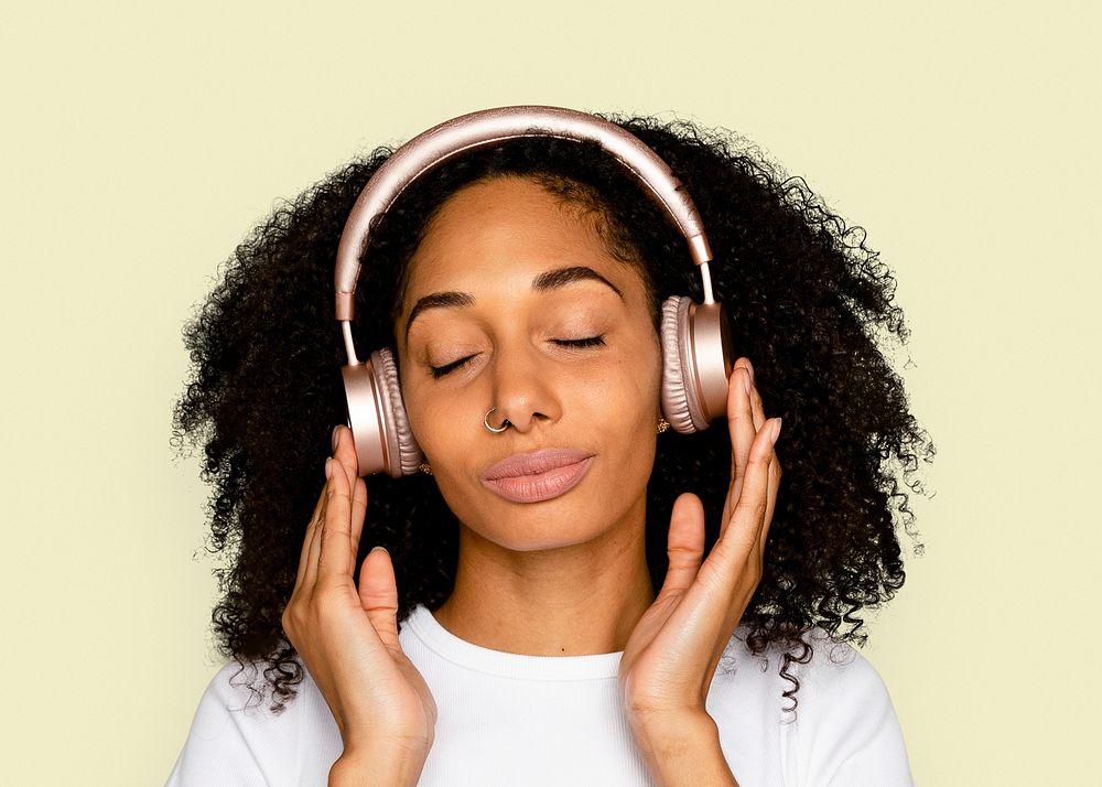 African woman, listening to music through headphones portrait