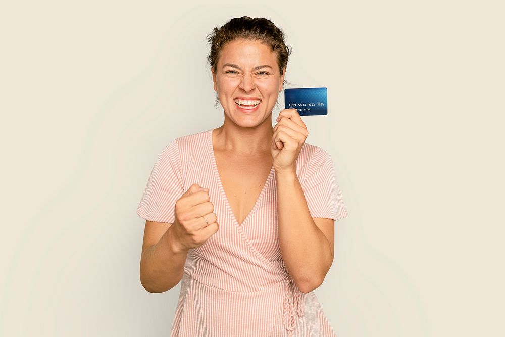 Cheerful shopaholic woman holding credit card cashless payment