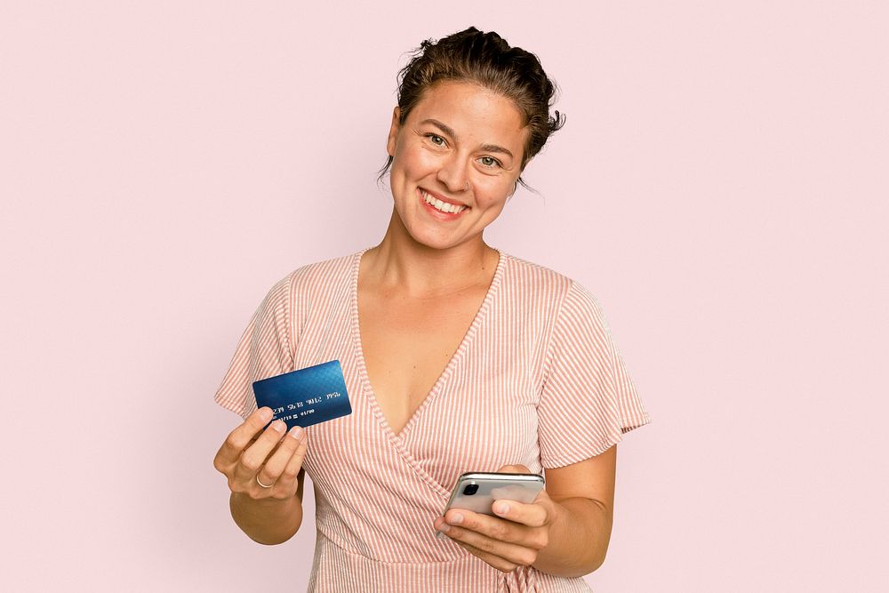 Cheerful shopaholic woman holding credit card cashless payment