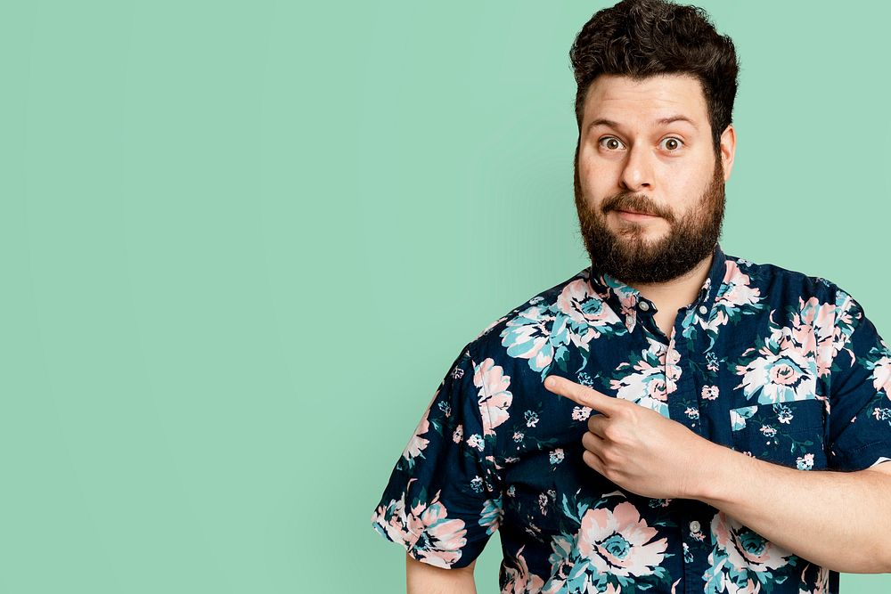 Bearded man in floral summer shirt pointing to the side