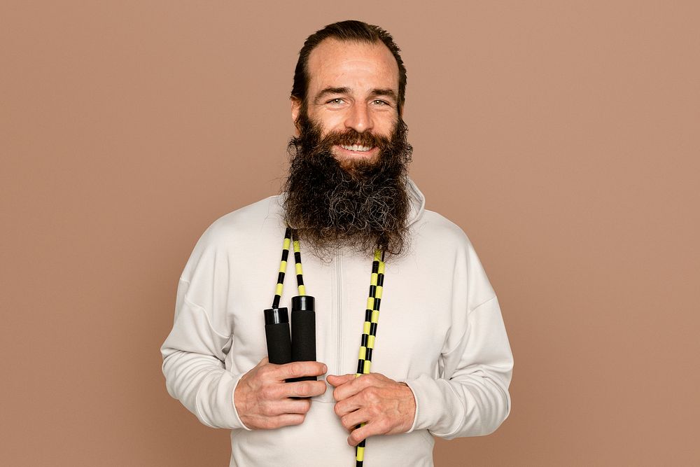 Healthy bearded man with skipping rope around his neck