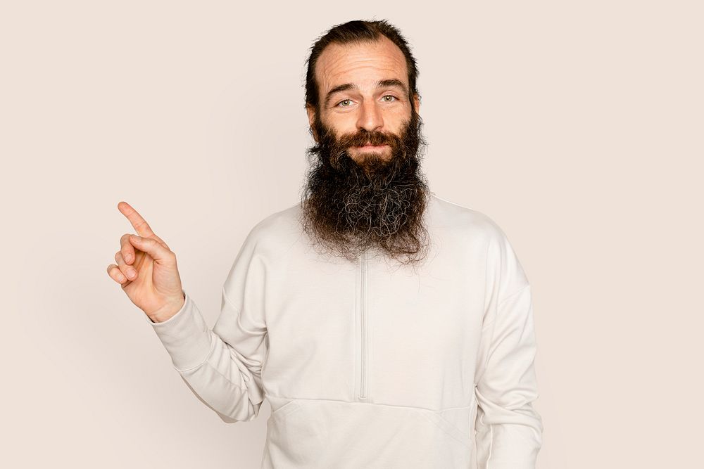 Bearded man smiling and pointing to the side