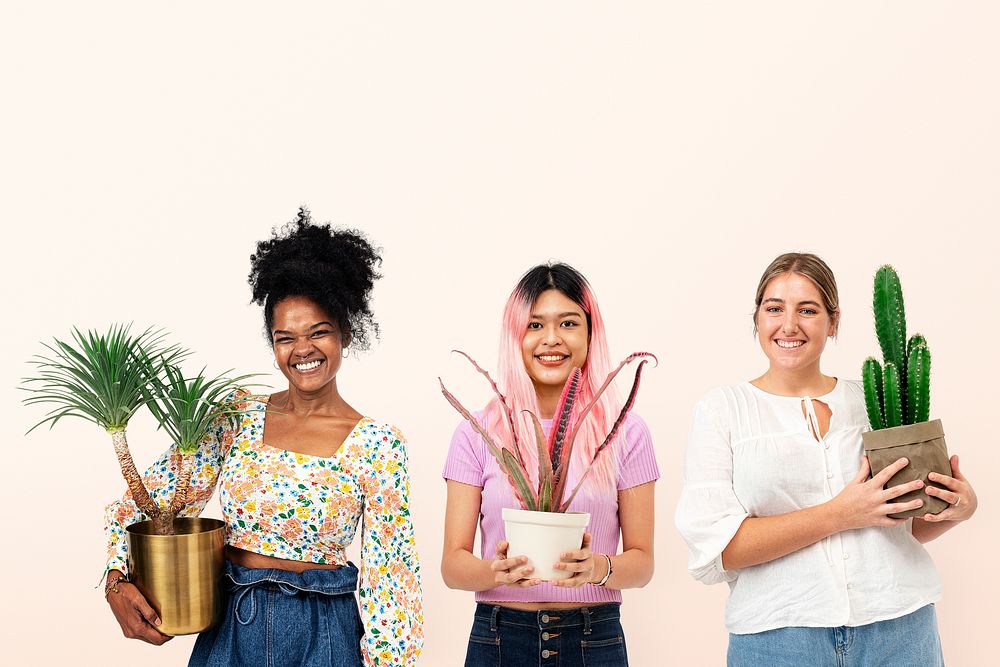 Happy women plant lovers holding potted houseplants