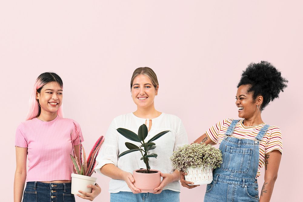 Happy women plant lovers holding potted houseplants