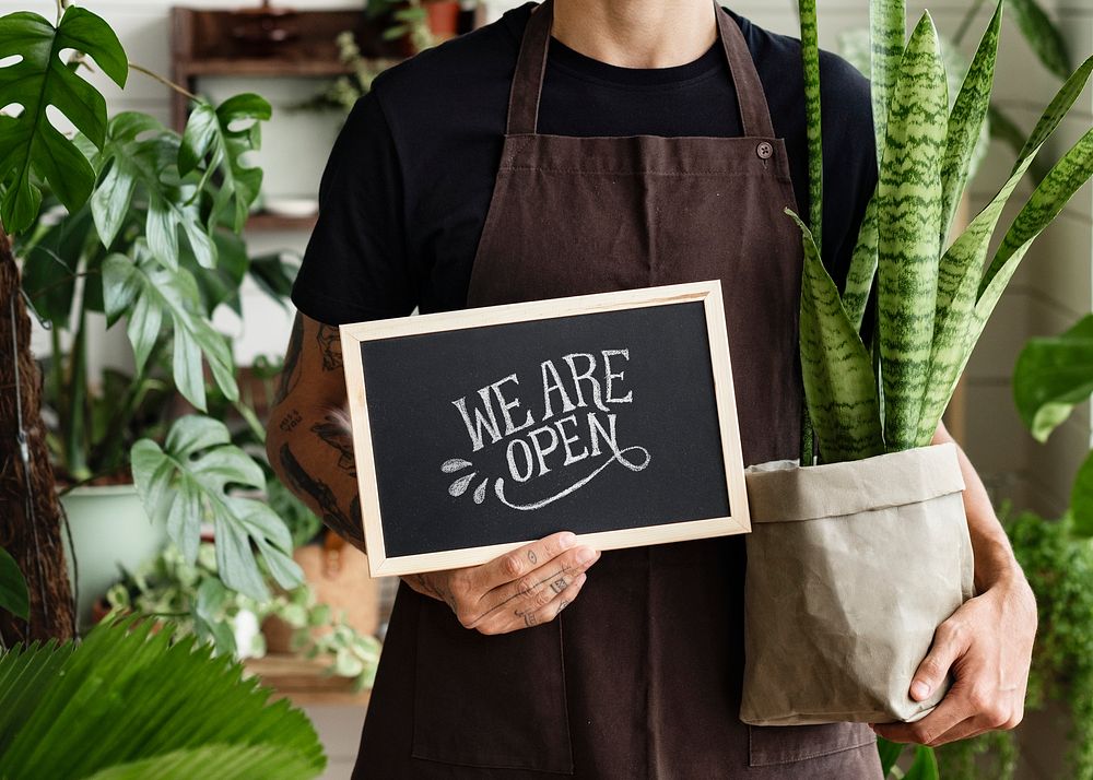 Business owner holding we are open sign