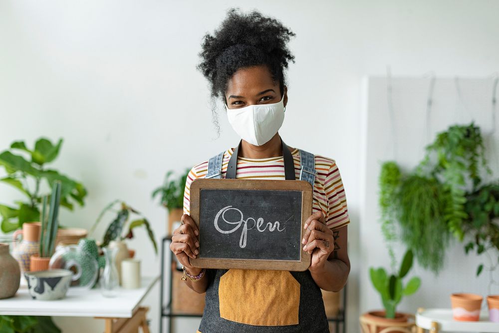 Business owner holding open sign in the new normal