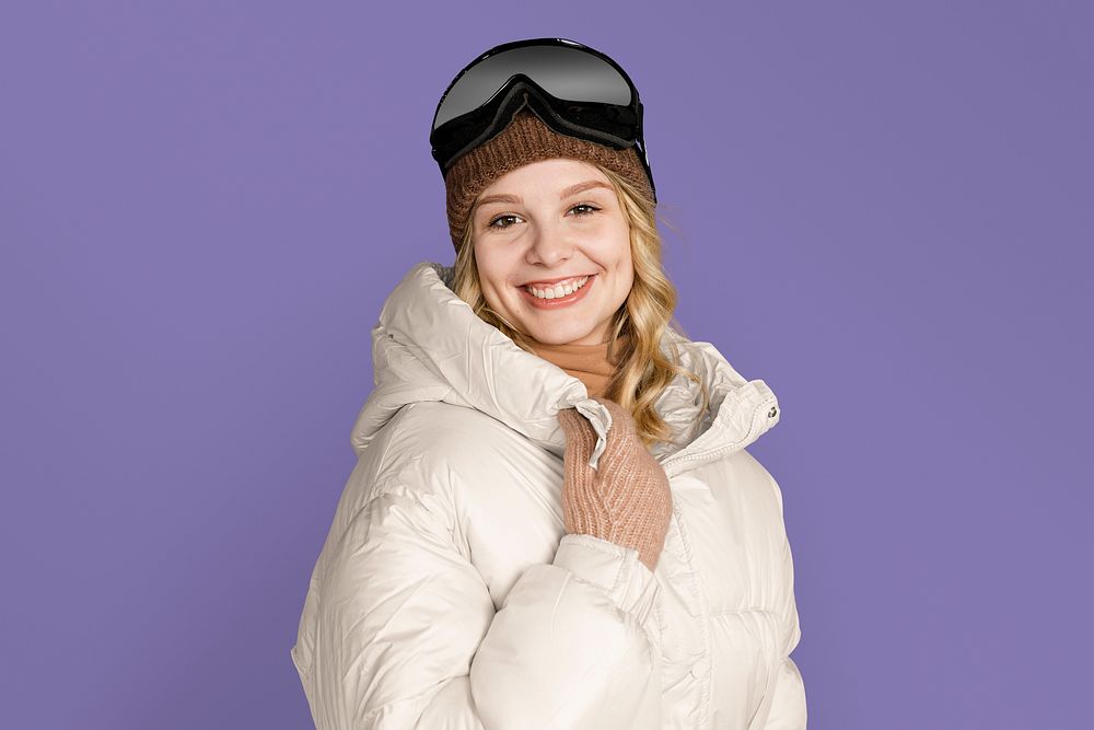 Happy woman with ski goggles, on purple background